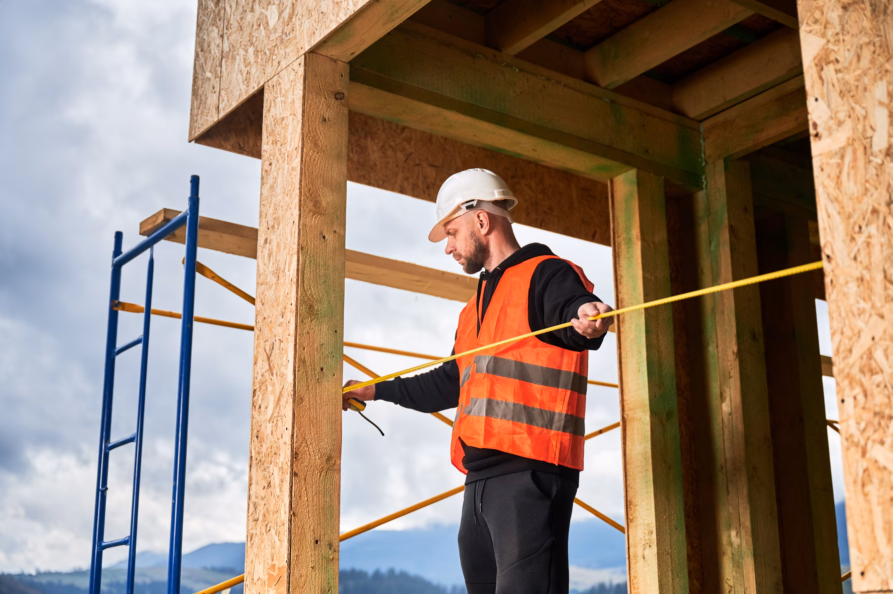 Construction specialist measuring a townhouse structure
